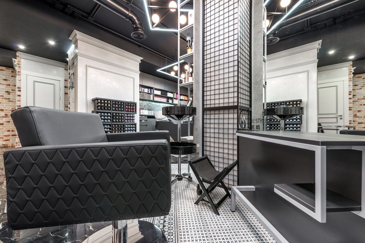Het interieur van Studio Kam met drie kappersstoelen en grote spiegels
